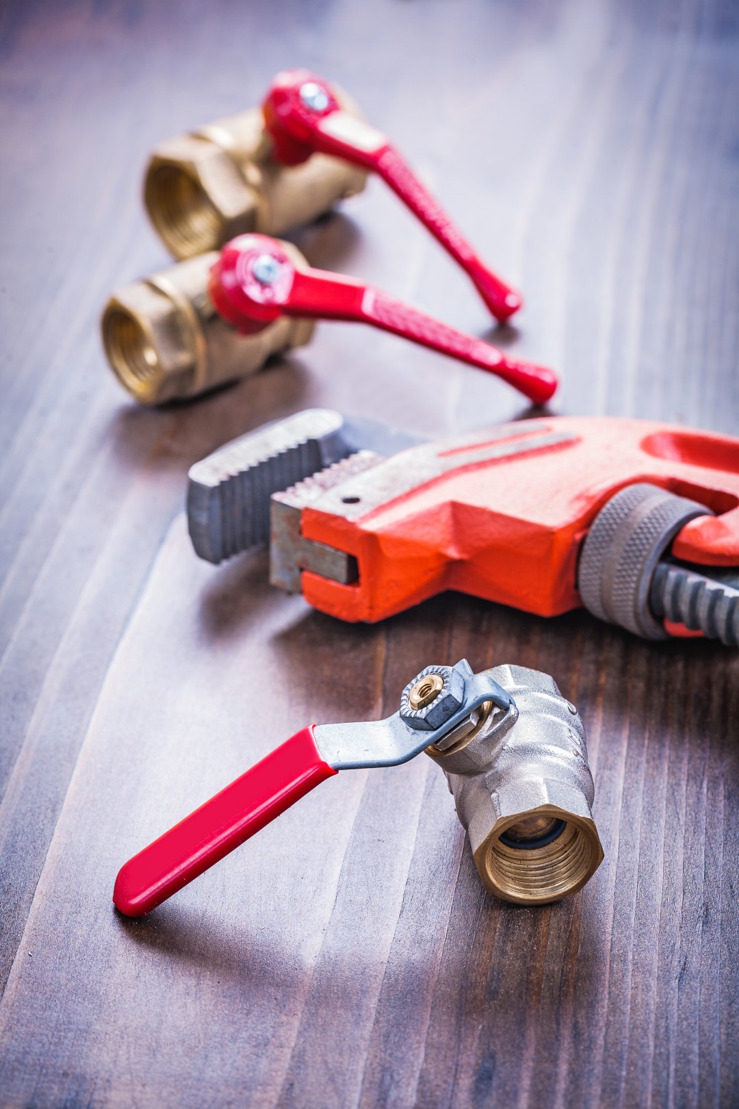 plumbing tools laying on a wooden surface