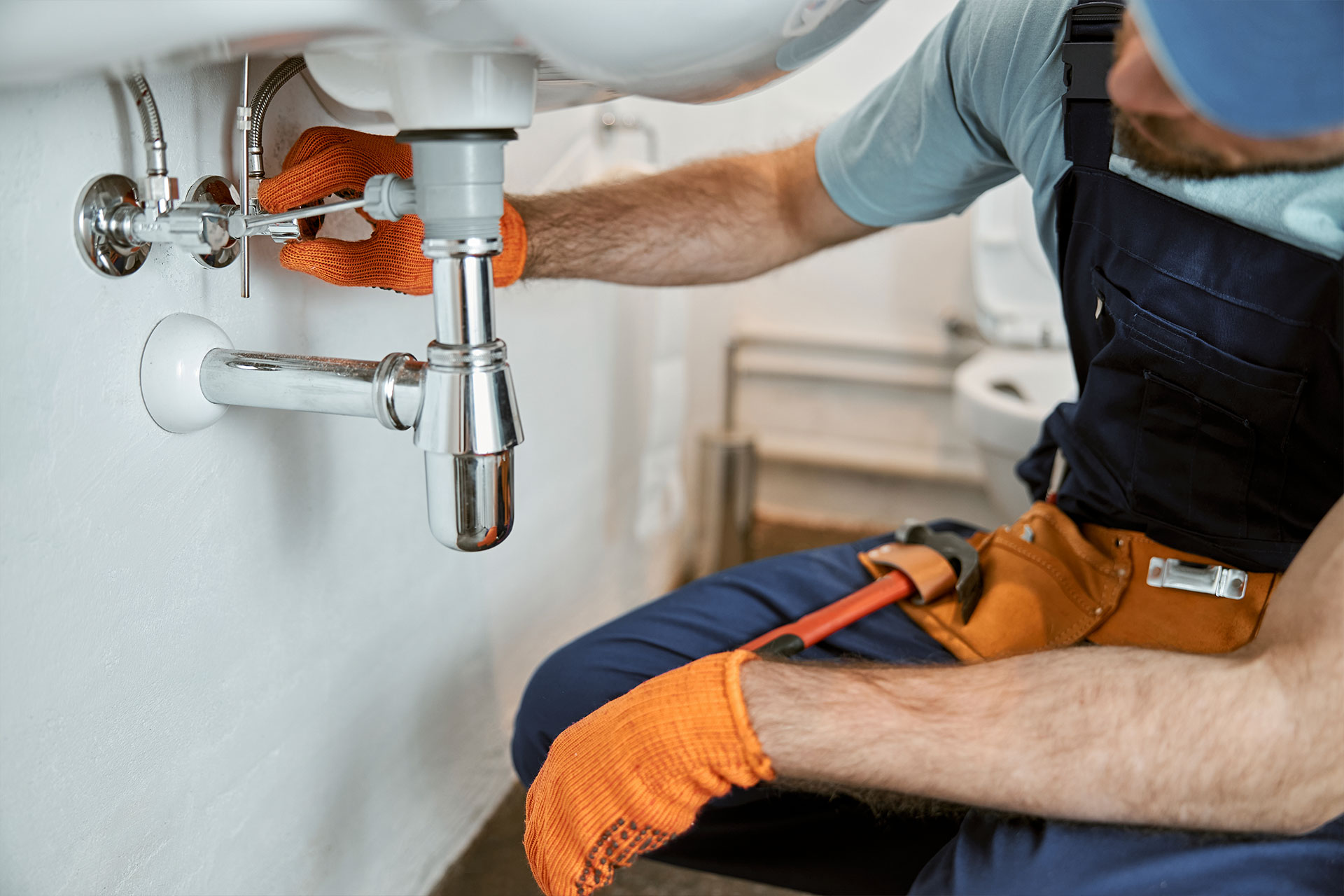 plumber working underneath a bathroom sink